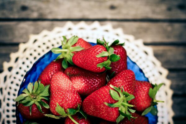 Erdbeeren in einem blauen Teller auf einer Spitzenserviette