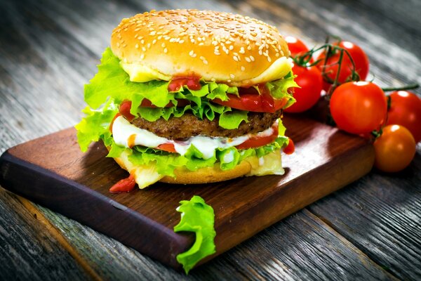 Juicy Hamburger with cutlet, tomatoes and sauce