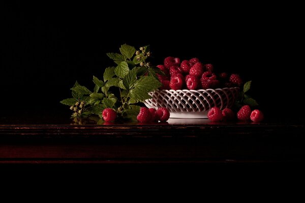 Nature morte aux framboises dans des couleurs sombres