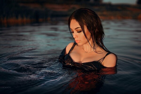 Morena en traje en el agua de la tarde