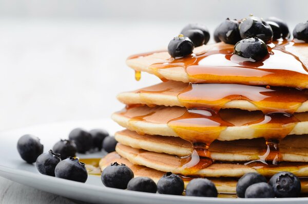 Crêpes sur une assiette de miel et de bleuets