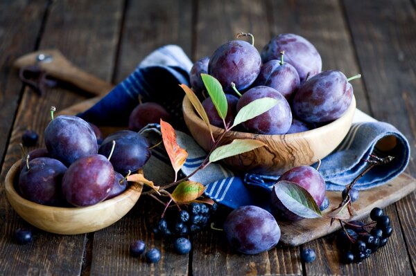 Plums and black currants on wooden plates