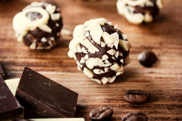 Süße Bonbons aus schwarzer Schokolade mit weißer Schokolade bestreut