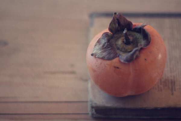 Reife Persimmon liegt auf dem Buch