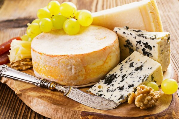 Formaggio, uva e coltello su un vassoio