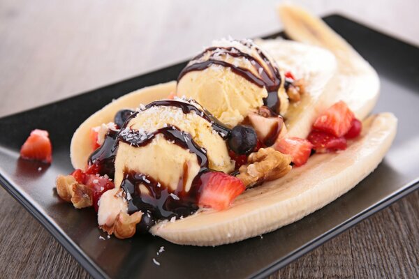 Dessert aus Eis mit Banane, Erdbeeren und Schokolade
