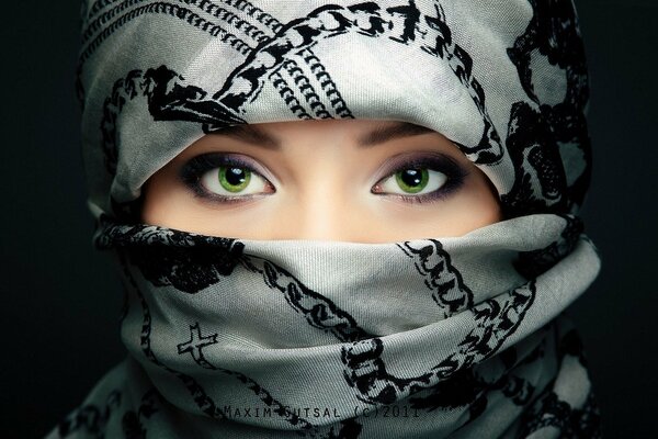 Ojos verdes de una chica con la cara oculta
