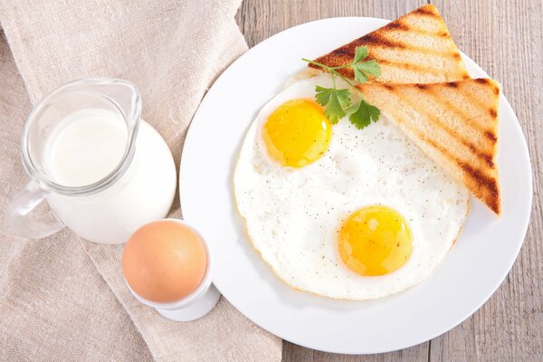 Breakfast of scrambled eggs, toast and milk