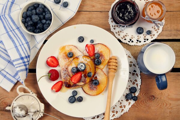 Pfannkuchen auf einem Teller mit Erdbeeren und Marmelade