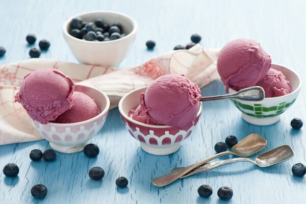 Drei Desserts mit Eis und einem Teller Blaubeeren