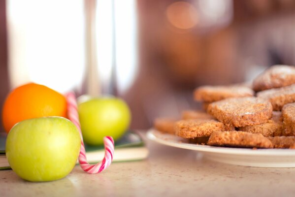 Table sur laquelle se trouvent des pommes et une assiette de biscuits