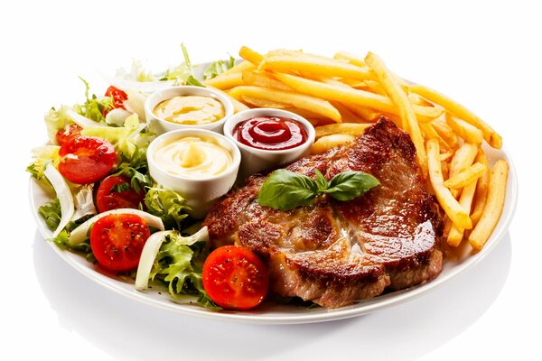 Carne asada con ensalada de verduras, papas fritas y tres salsas en un plato blanco