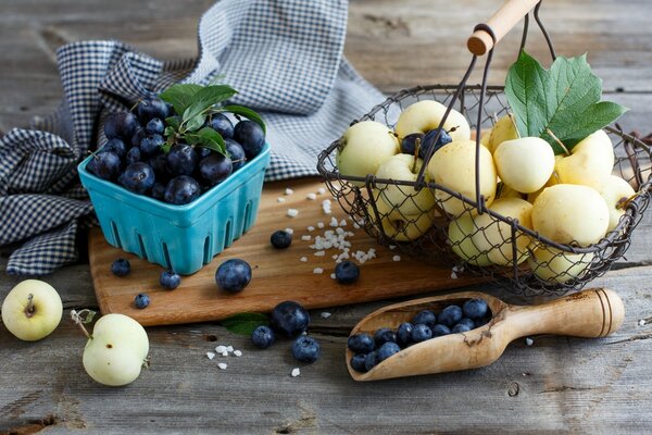 Arándanos y manzanas en una composición en una bandeja de madera