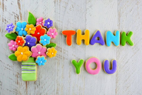Galletas con glaseado multicolor en forma de una frase Thank You y un ramo de flores