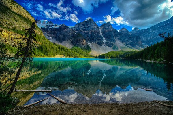 Mountains and clouds are reflected in the clear water of the mountain lake