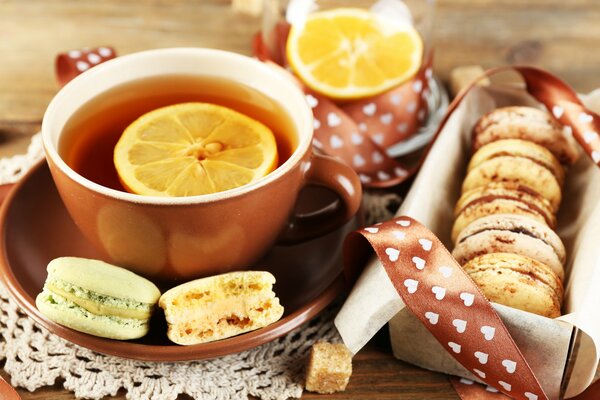 Taza de té con limón y empanadas francesas