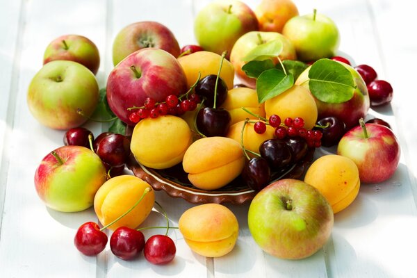 Frutas y bayas sobre la mesa: albaricoques, manzanas, cerezas, bayas