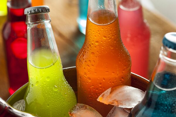 Bottles with colorful drinks in an ice bucket