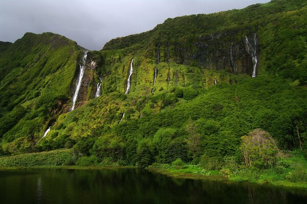 Landscape depicting green mountains and waterfalls