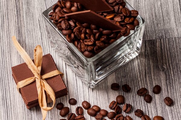 Grains de café et pile de barres de chocolat attachées avec un ruban