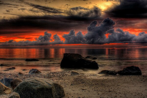 Sunset fascinates on the horizon with clouds, sea, shore