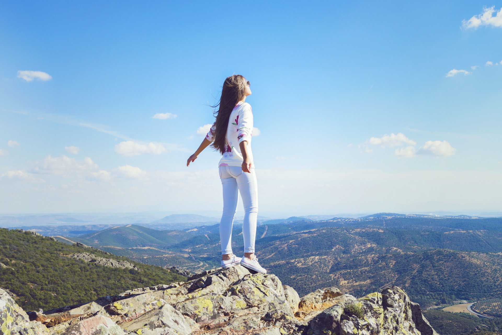 girl mountain jeans wind hair pose is horizon sky cloud