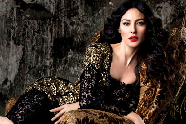 Monica Bellucci sur une chaise en robe