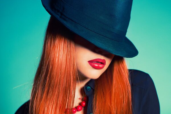 Red-haired girl with red lipstick in a hat