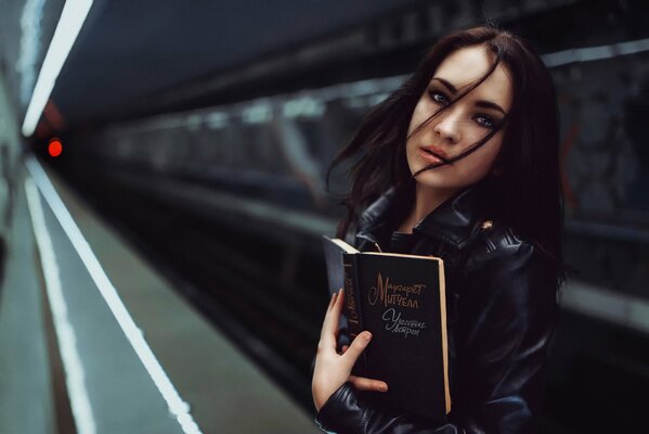 Chica en el metro con el libro lo que el viento se llevó