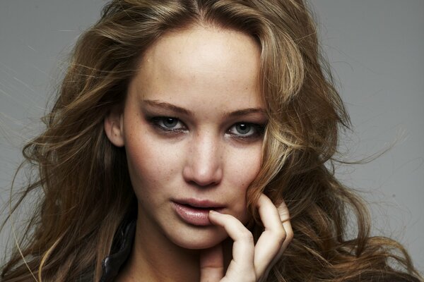 Portrait de Jennifer Lawrence avec la main près de la bouche