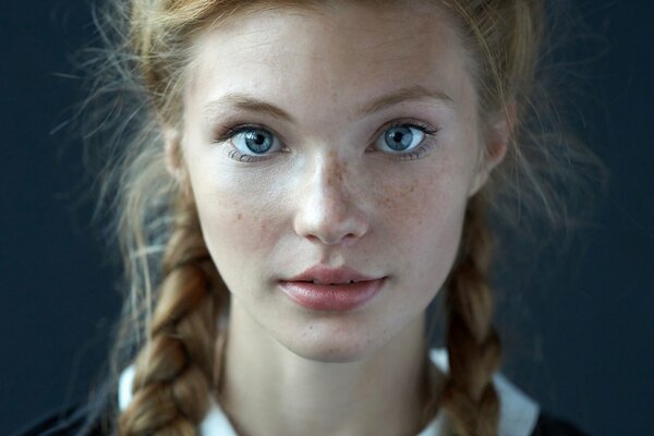 Jolie fille avec des nattes et des taches de rousseur