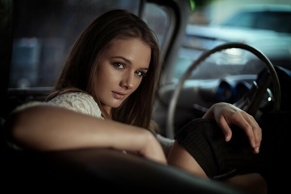 Porträt eines schönen Mädchens Natasha, das ein Auto fährt