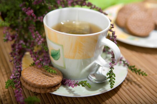 Taza de té con galletas sobre fondo de flores