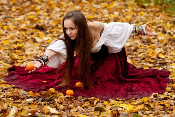 Fille aux cheveux noirs avec des fruits sur le feuillage