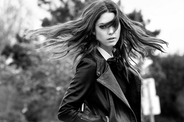 Czarno-białe zdjęcie dziewczyny w kurtce z luźnymi włosami