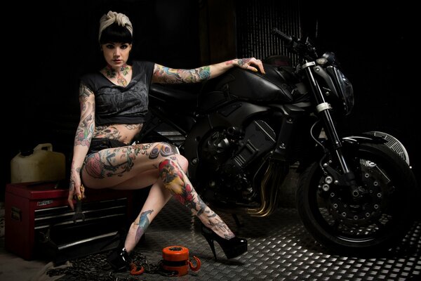 The girl with tattoos at the motorcycle