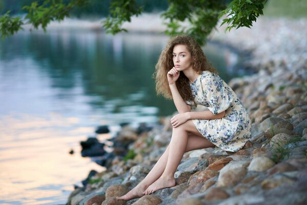 Brown-eyed girl in a dress on the rocks