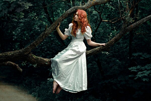 Red-haired girl Polina in the forest on a branch