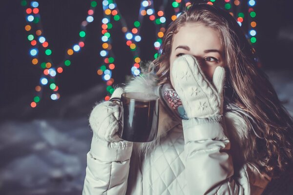 Ragazza con una tazza di bevanda calda in inverno