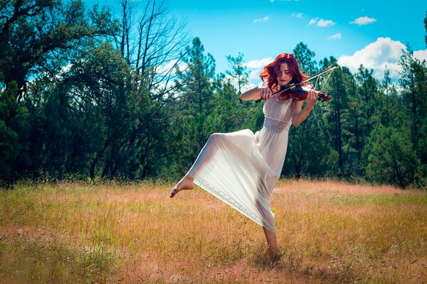 Niña violinista en el campo bailando