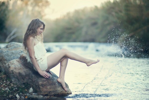 Una sirena llega a la orilla y se sienta en una piedra