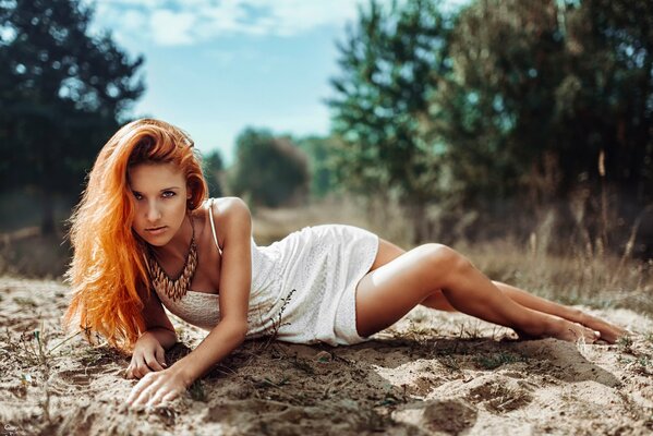 Rousse fille en robe posant dans la nature