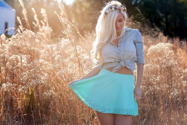 Blonde in a short skirt posing against the background of nature