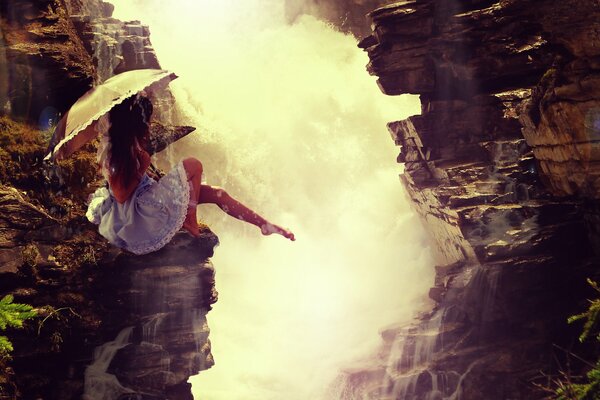 A girl with an umbrella came to see the waterfall