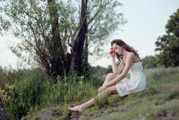 Foto de una chica con un vestido blanco en la naturaleza