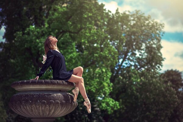 Ballerina in pointe shoes under the sun