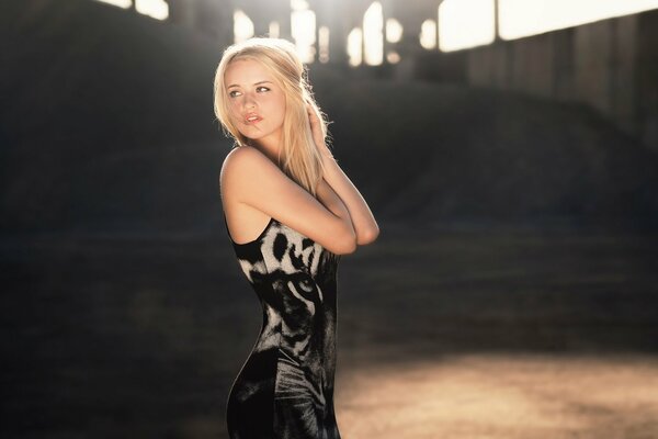 Hermosa rubia con un vestido negro. vestido con un tigre en una chica