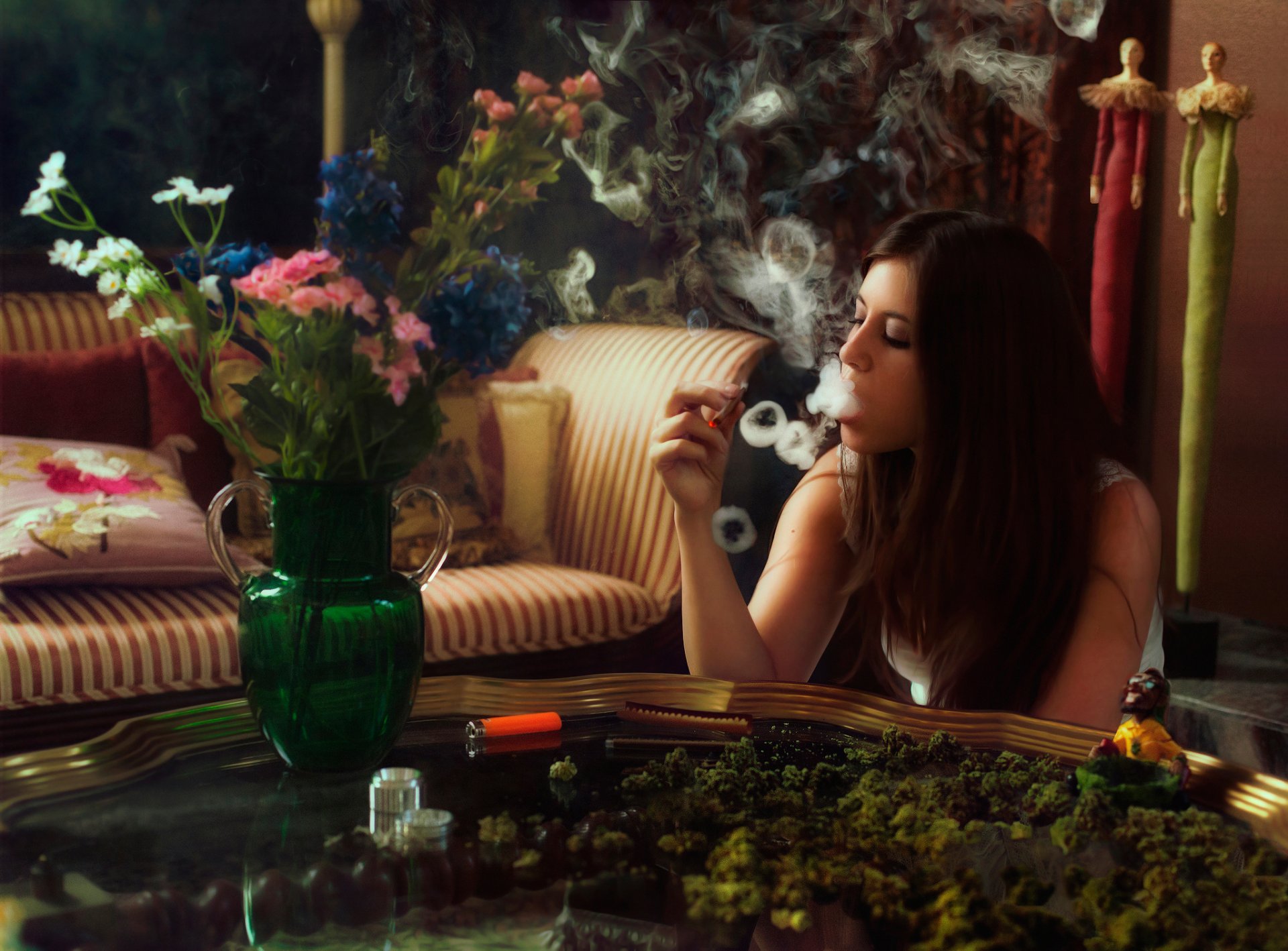 chica fuma porro humo anillos mesa florero flores apagar cáñamo