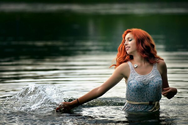 Red-haired model plays in the water