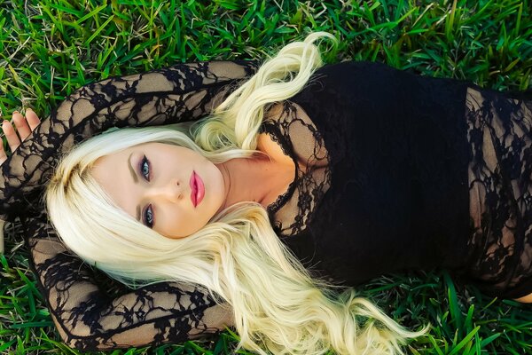 A bright blonde with a soulful look on the grass